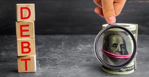 Dollari di soldi e l'iscrizione “debito “ Pagamento delle tasse e del debito allo stato Concetto della crisi finanziaria e dei pr fotografie stock Dollari di soldi e l'iscrizione “debito “ Pagamento delle tasse e del debito allo stato Concetto della crisi finanziaria e dei pr fotografie stock