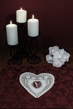 Dollie et pierre gemme en forme de coeur, trois bougies blanches dans des supports en métal et bouquet des roses blanches sur la images libres de droits Dollie et pierre gemme en forme de coeur, trois bougies blanches dans des supports en métal et bouquet des roses blanches sur la images libres de droits