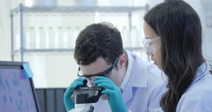 Dolly Shot des scientifiques Team Work de recherches médicales sur le laboratoire moderne avec des scientifiques entreprenant des banque de vidéos Dolly Shot des scientifiques Team Work de recherches médicales sur le laboratoire moderne avec des scientifiques entreprenant des banque de vidéos