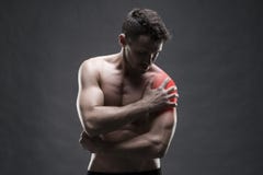 Dolor en el hombro Carrocería masculina muscular Culturista hermoso que presenta en fondo gris imágenes de archivo libres de regalías Dolor en el hombro Carrocería masculina muscular Culturista hermoso que presenta en fondo gris imágenes de archivo libres de regalías