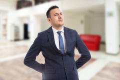 Dolore lombo-sacrale di sofferenza di agente immobiliare o dell'agente immobiliare Immagine Stock Dolore lombo-sacrale di sofferenza di agente immobiliare o dell'agente immobiliare Immagine Stock