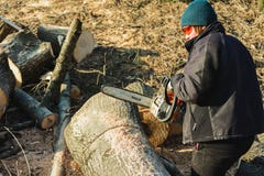 Dolyna, Ucrania, el 25 de febrero de 2019 Una mujer talla una hierba que el cincel vio el árbol de Stihl para cosechar la leña en fotografía de archivo libre de regalías Dolyna, Ucrania, el 25 de febrero de 2019 Una mujer talla una hierba que el cincel vio el árbol de Stihl para cosechar la leña en fotografía de archivo libre de regalías