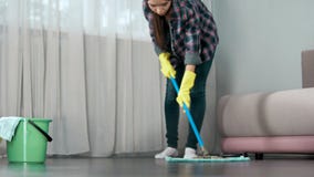 Domestica che lava con attenzione pavimento di camera di albergo prima dell'arrivo degli ospiti, pulente fotografia stock libera da diritti Domestica che lava con attenzione pavimento di camera di albergo prima dell'arrivo degli ospiti, pulente fotografia stock libera da diritti