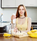 Dona de casa alegre que cozinha com bananas fotografia de stock Dona de casa alegre que cozinha com bananas fotografia de stock