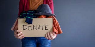Donation Concept. Woman holding a Donate Box with full of Clothe stock image Donation Concept. Woman holding a Donate Box with full of Clothe stock image