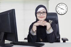 Donna abbastanza araba che sorride nell'ufficio fotografie stock libere da diritti Donna abbastanza araba che sorride nell'ufficio fotografie stock libere da diritti
