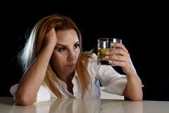 Donna alcolica ubriaca sprecata e tenuta diminuita che sembra premurosa al vetro del whiskey scozzese fotografia stock Donna alcolica ubriaca sprecata e tenuta diminuita che sembra premurosa al vetro del whiskey scozzese fotografia stock