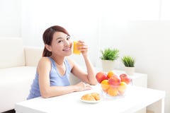 Donna allegra che beve un succo d'arancia immagini stock libere da diritti Donna allegra che beve un succo d'arancia immagini stock libere da diritti