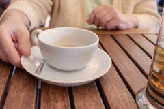 Donna anziana che si siede dalla tavola e che tiene una tazza di tè immagine stock libera da diritti Donna anziana che si siede dalla tavola e che tiene una tazza di tè immagine stock libera da diritti