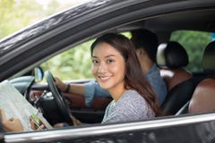 Donna asiatica che usando smartphone e mappa ed uomini che conducono automobile su roa immagine stock libera da diritti Donna asiatica che usando smartphone e mappa ed uomini che conducono automobile su roa immagine stock libera da diritti