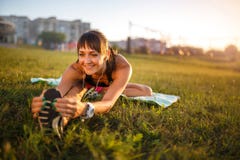 Donna atletica che allunga il suo tendine del ginocchio, forma fisica di addestramento di esercizio di gambe prima dell'allenamen immagine stock Donna atletica che allunga il suo tendine del ginocchio, forma fisica di addestramento di esercizio di gambe prima dell'allenamen immagine stock