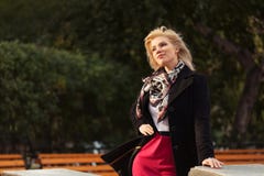 Donna bionda di giovane modo felice che cammina nel parco di autunno immagine stock Donna bionda di giovane modo felice che cammina nel parco di autunno immagine stock