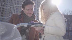 Donna bionda graziosa ed uomo bello alla via della città con la bicicletta che guarda nel telefono cellulare della signora Svago archivi video Donna bionda graziosa ed uomo bello alla via della città con la bicicletta che guarda nel telefono cellulare della signora Svago archivi video
