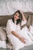 Donna castana attraente nell'interno domestico d'annata Bello modello femminile in un maglione bianco che si siede sul sofà su bi immagine stock libera da diritti Donna castana attraente nell'interno domestico d'annata Bello modello femminile in un maglione bianco che si siede sul sofà su bi immagine stock libera da diritti