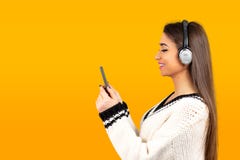 Donna che ascolta la musica con le cuffie sul cellulare fotografia stock libera da diritti Donna che ascolta la musica con le cuffie sul cellulare fotografia stock libera da diritti
