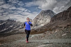 Donna che corre giù la strada e nei precedenti un paesaggio montagnoso delle alpi italiane fotografie stock libere da diritti Donna che corre giù la strada e nei precedenti un paesaggio montagnoso delle alpi italiane fotografie stock libere da diritti