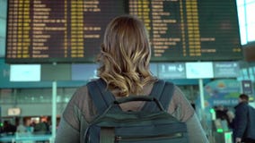 Donna che esamina il bordo di informazioni in aeroporto video d archivio Donna che esamina il bordo di informazioni in aeroporto video d archivio