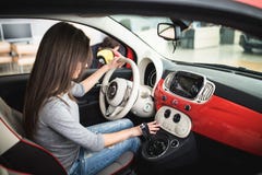 Donna che guida nuovi ed automobile e bottone moderni di giro sul pannello del cruscotto in automobile immagine stock libera da diritti Donna che guida nuovi ed automobile e bottone moderni di giro sul pannello del cruscotto in automobile immagine stock libera da diritti