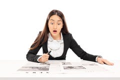 Donna che legge le notizie tramite una lente d'ingrandimento Fotografia Stock Donna che legge le notizie tramite una lente d'ingrandimento Fotografia Stock