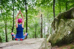 Donna che medita nella posa del loto, facente yoga su roccia fotografia stock libera da diritti Donna che medita nella posa del loto, facente yoga su roccia fotografia stock libera da diritti