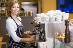 Donna che produce caffè nel sorridere del ristorante immagini stock libere da diritti Donna che produce caffè nel sorridere del ristorante immagini stock libere da diritti