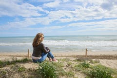 Donna che si siede alla spiaggia Immagine Stock Libera da Diritti Donna che si siede alla spiaggia Immagine Stock Libera da Diritti