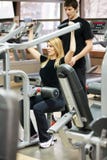Donna con il suo istruttore personale di forma fisica nella palestra immagine stock Donna con il suo istruttore personale di forma fisica nella palestra immagine stock