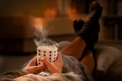 Donna con la bevanda che si trova sul sofà fotografie stock libere da diritti Donna con la bevanda che si trova sul sofà fotografie stock libere da diritti