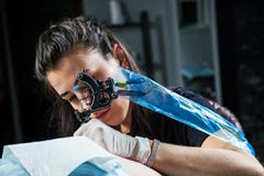 Donna del tatuatore che fa tatuaggio fotografia stock Donna del tatuatore che fa tatuaggio fotografia stock