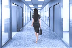 Donna di affari che cammina nel corridoio dell'ufficio Immagine Stock Donna di affari che cammina nel corridoio dell'ufficio Immagine Stock