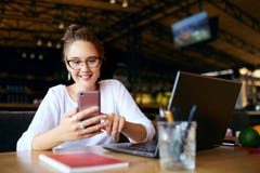 Donna di affari della corsa mista che scrive un testo a macchina sullo smartphone Femmina asiatica che tiene un cellulare moderno immagine stock Donna di affari della corsa mista che scrive un testo a macchina sullo smartphone Femmina asiatica che tiene un cellulare moderno immagine stock