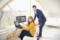 Donna di affari esecutiva e giovane businessma di aiuto finanziario Fotografia Stock Donna di affari esecutiva e giovane businessma di aiuto finanziario Fotografia Stock