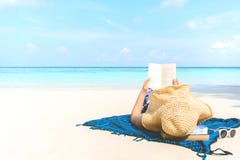 Donna di festa della spiaggia di estate che legge un libro sulla spiaggia a tempo il tempo libero immagini stock Donna di festa della spiaggia di estate che legge un libro sulla spiaggia a tempo il tempo libero immagini stock