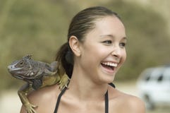 Donna di risata con l'iguana sulla spalla immagine stock libera da diritti Donna di risata con l'iguana sulla spalla immagine stock libera da diritti