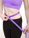 Donna di riserva della foto che misura il suo corpo esile isolato su fondo bianco fotografie stock libere da diritti Donna di riserva della foto che misura il suo corpo esile isolato su fondo bianco fotografie stock libere da diritti