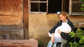 Donna esaurita, madre con un infante nelle sue armi sui precedenti delle case bombardate Guerra, terremoto, fuoco archivi video Donna esaurita, madre con un infante nelle sue armi sui precedenti delle case bombardate Guerra, terremoto, fuoco archivi video
