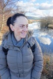 Donna felice e sorridente accanto al lago Immagine Stock Libera da Diritti Donna felice e sorridente accanto al lago Immagine Stock Libera da Diritti