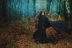 Donna misteriosa che cammina nella foresta magica fotografie stock libere da diritti Donna misteriosa che cammina nella foresta magica fotografie stock libere da diritti