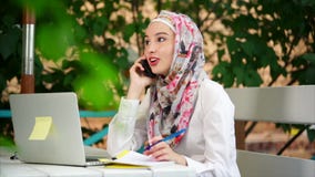 Donna musulmana che fa telefonata di affari Donna musulmana che fa telefonata di affari
