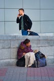 Donna senza tetto povera e riuscito uomo vicino alla stazione ferroviaria immagini stock libere da diritti Donna senza tetto povera e riuscito uomo vicino alla stazione ferroviaria immagini stock libere da diritti