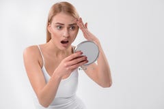 Donna sorpresa osservando la sua pelle facciale fotografia stock libera da diritti Donna sorpresa osservando la sua pelle facciale fotografia stock libera da diritti