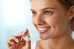 Donna sorridente con il bello sorriso facendo uso dell'istruttore invisibile dei denti fotografia stock libera da diritti Donna sorridente con il bello sorriso facendo uso dell'istruttore invisibile dei denti fotografia stock libera da diritti