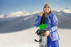 Donna sorridente felice con lo snowboard sulla collina della montagna fotografia stock libera da diritti Donna sorridente felice con lo snowboard sulla collina della montagna fotografia stock libera da diritti