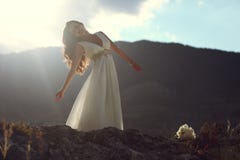 Donna splendida in vestito bianco alla luce di sera fotografia stock Donna splendida in vestito bianco alla luce di sera fotografia stock