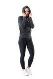 Donna sportiva in abiti sportivi caldi di autunno con la maglia con cappuccio sulla testa che esamina macchina fotografica immagini stock Donna sportiva in abiti sportivi caldi di autunno con la maglia con cappuccio sulla testa che esamina macchina fotografica immagini stock