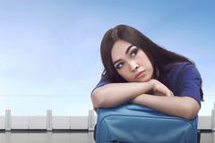 Donna turistica asiatica annoiata che aspetta con i bagagli Fotografia Stock Libera da Diritti Donna turistica asiatica annoiata che aspetta con i bagagli Fotografia Stock Libera da Diritti