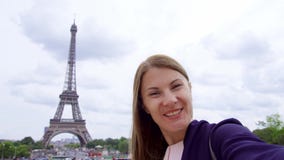 Donna vicino alla torre Eiffel facendo uso del cellulare che parla via il messaggero app Donna turistica sorridente che viaggia i stock footage Donna vicino alla torre Eiffel facendo uso del cellulare che parla via il messaggero app Donna turistica sorridente che viaggia i stock footage