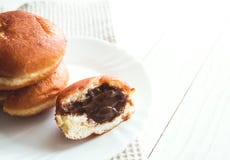 Donuts с шоколадом заполняя на белой плите, белом деревянном космосе экземпляра предпосылки стоковое фото Donuts с шоколадом заполняя на белой плите, белом деревянном космосе экземпляра предпосылки стоковое фото