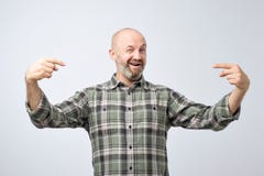 Dorośleć łysego dorosłego mężczyzna stoi nad popielatą grunge ścianą patrzeje ufny z uśmiechem na twarzy z brodą fotografia royalty free Dorośleć łysego dorosłego mężczyzna stoi nad popielatą grunge ścianą patrzeje ufny z uśmiechem na twarzy z brodą fotografia royalty free