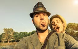 Dos amigos jovenes de los inconformistas que toman el selfie al aire libre en días de fiesta - F fotografía de archivo Dos amigos jovenes de los inconformistas que toman el selfie al aire libre en días de fiesta - F fotografía de archivo